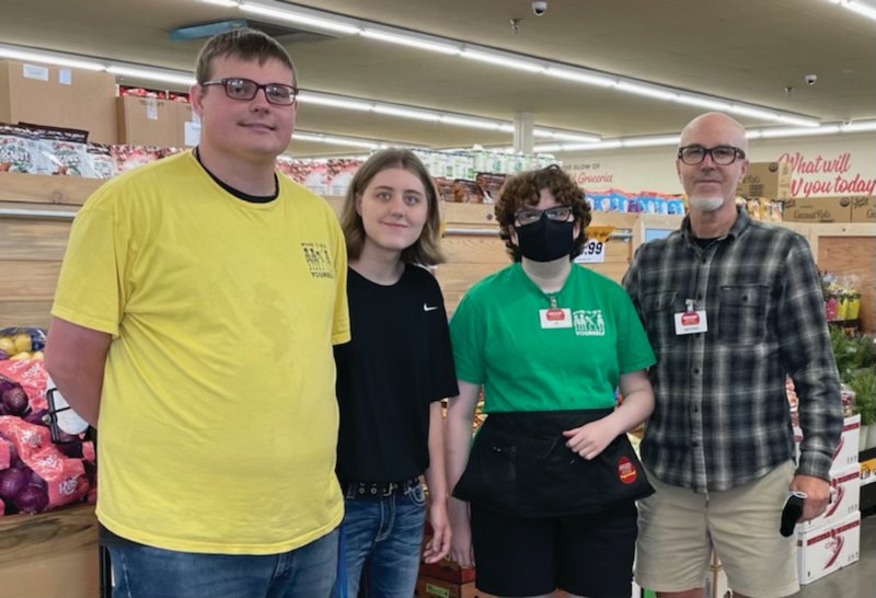 Grocery Outlet co-owner Michael Morgan (far right) poses with some of his employees. About 20 percent of his workforce have some form of disability. He calls hiring those with disabilities “the right thing to do.”